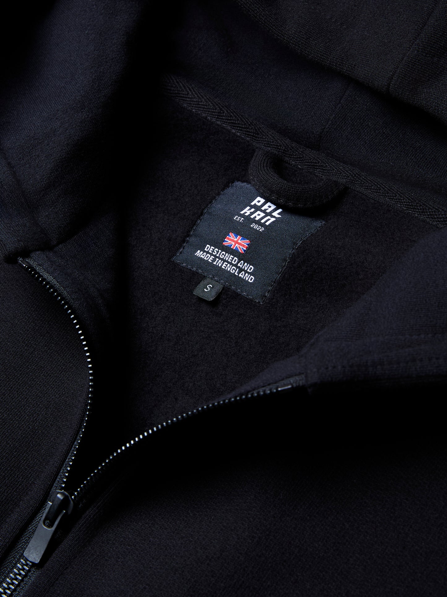 The RIGEL hoodie from PALKAN, a custom designed full-zip hoodie with wrist and shoulder pleats, zoomed in on the neck