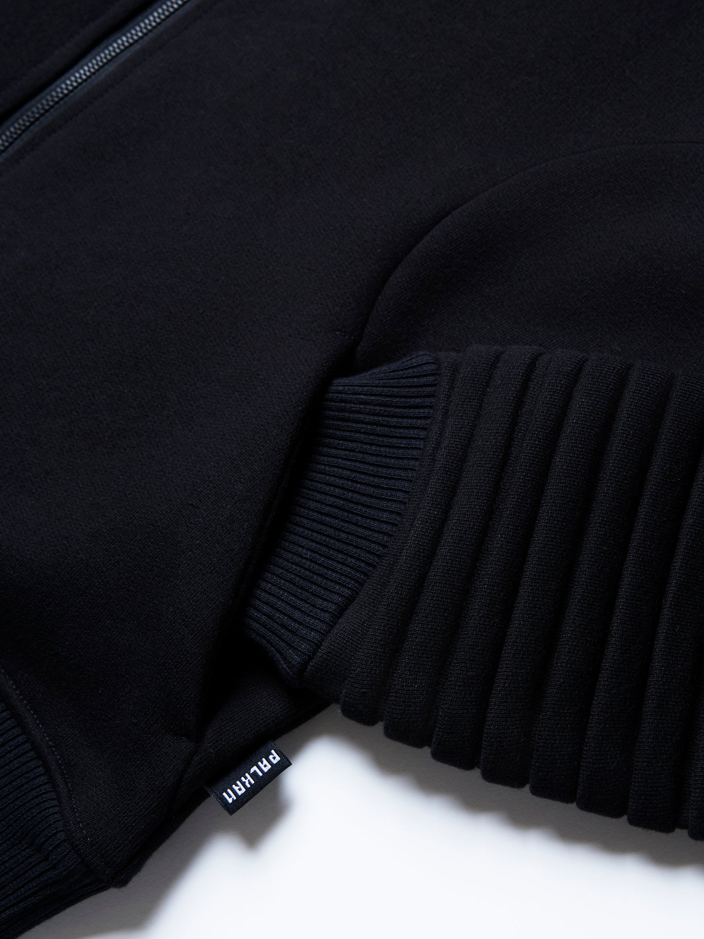 The RIGEL hoodie from PALKAN, a custom designed full-zip hoodie with wrist and shoulder pleats, zoomed in on the pocket detail