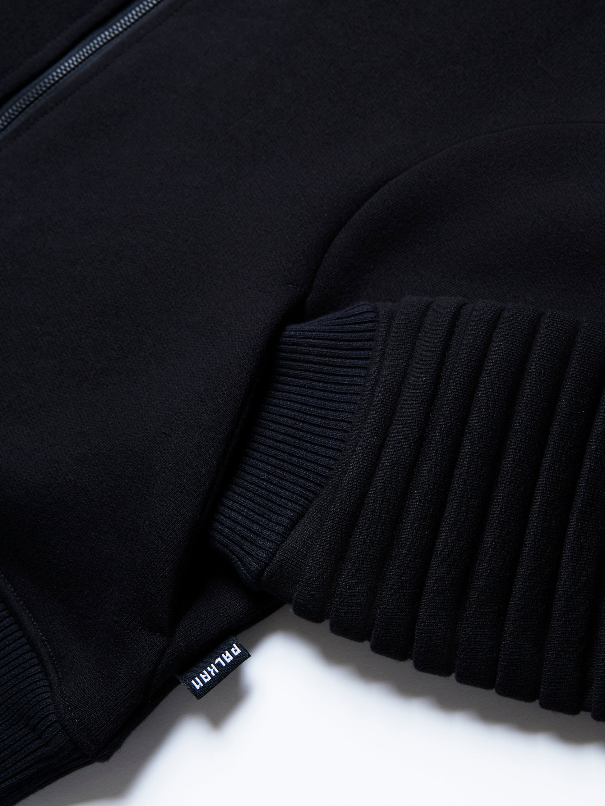 The RIGEL hoodie from PALKAN, a custom designed full-zip hoodie with wrist and shoulder pleats, zoomed in on the pocket detail